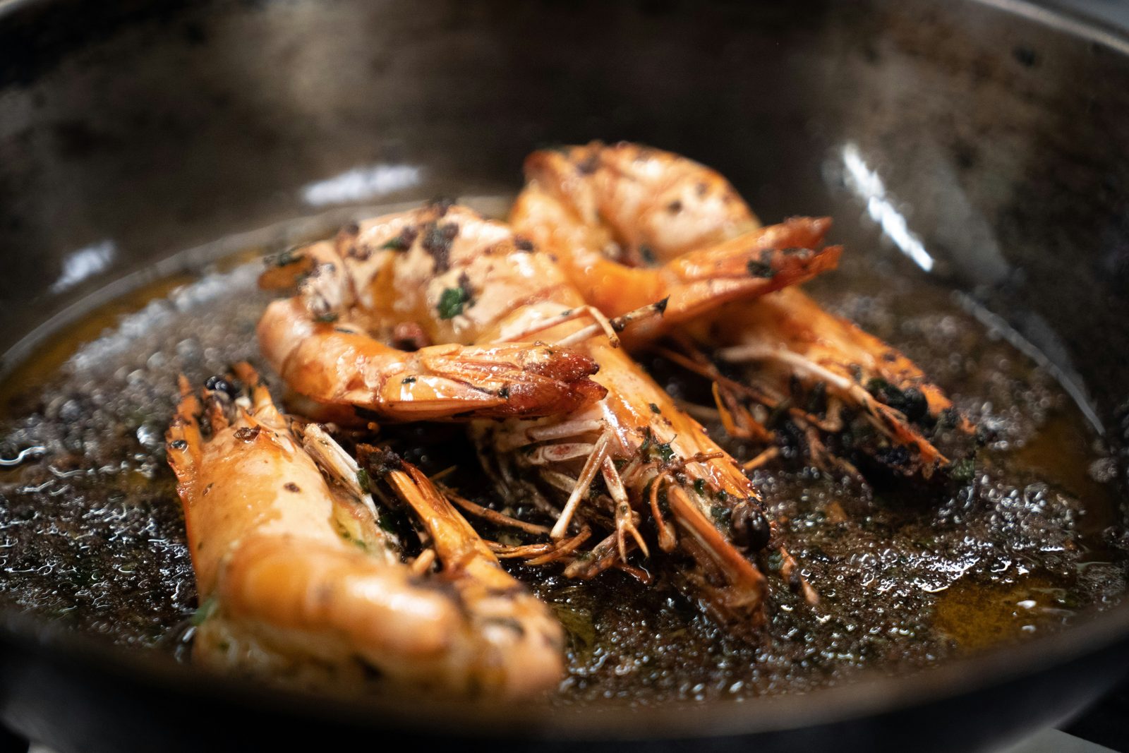 Prawns sizzling in a pan